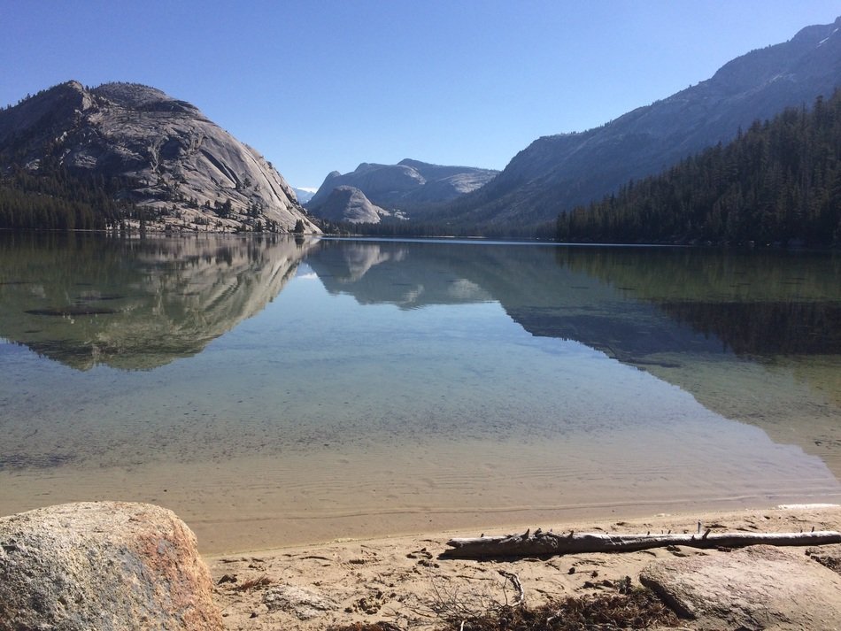 reflection of mountains in the lake on a sunny day