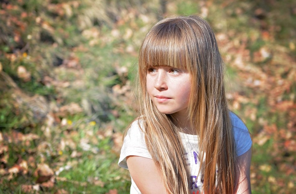 human child girl blond long hair in the forest