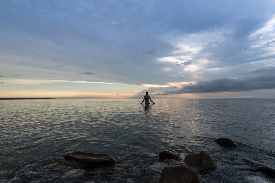 man in sea at dusk