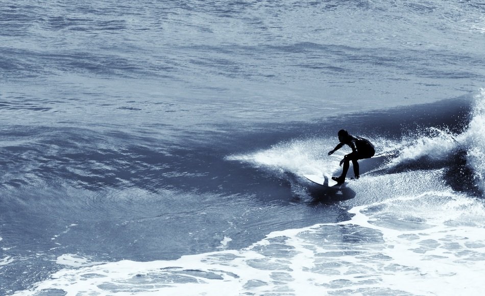 Person surfing on the waves on the surfboard