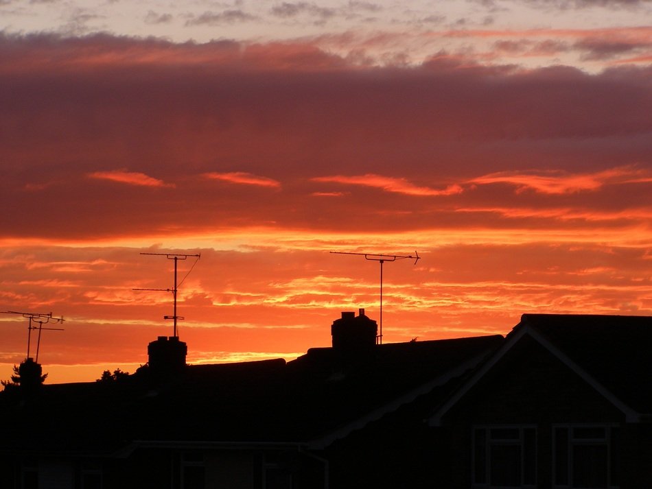sunset over silhouettes of roofs