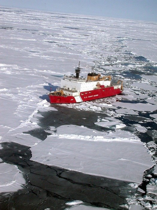 ship floating in ocean in Antarctica on a sunny day