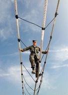 obstacle training, soldier walking on ropes at sky