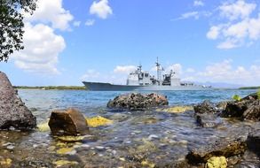 battleship near a rocky coastline