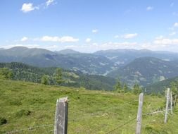 fenced pasture on mountain meadow in scenic landscape