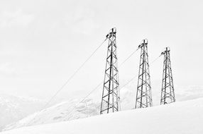 three steel masts on top of a snowy mountain