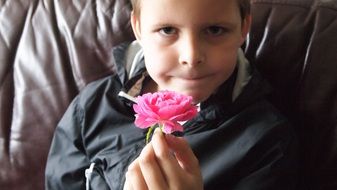 a rose in a boy's hand