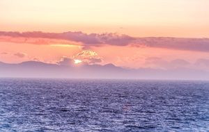 warm sunset at ocean with clouds