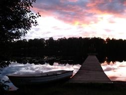 pink sunset over a wooden pier on the lake