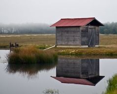 small barn reflected in the lake
