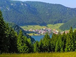 remote view of the village in a picturesque valley and forests on mountains