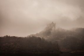 mountain castle covered by fog