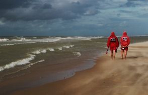 People on the beach under dark clouds