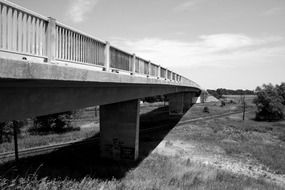 black and white photo of a stone bridge across the railroad tracks