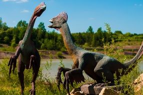 Colorful models of dinosaurs in the park with colorful plants