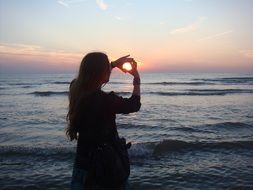 woman hugs sunshine by the sea in the Netherlands