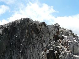 bottom view of the peak Aneto on a background cloudy sky
