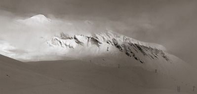 panoramic view of the alps in a snowy haze