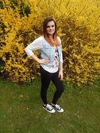 photo of a girl on a background of a yellow flowering bush