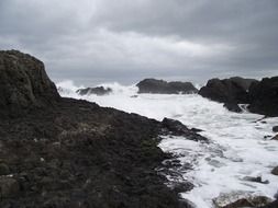 ocean foam at the foot of the rocks