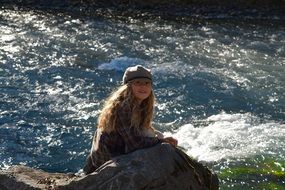 Blonde long haired smiling near mountain river