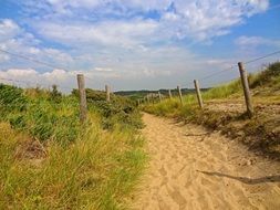 Landscape of the beautiful sandy path near the fence near North Sea