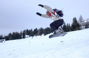 snowboarder jumping on a snowy slope