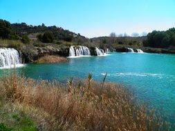 Beautiful waterfalls among the colorful plants near the blue lagoons of Rudeira in Spain