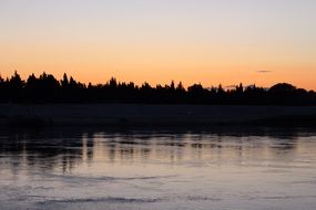 Silhouette trees near the lake in the evening