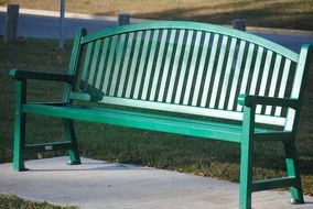 green bench in the sun in a park