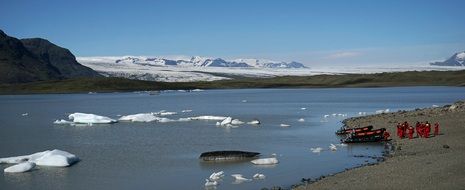 boats at coast of lake in view of scenic glacier, iceland, vatnajökull