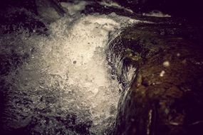 splash waterfall on stones in mountains