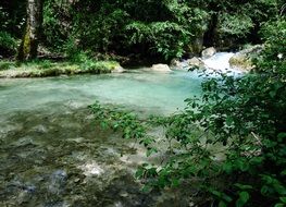 Beautiful fall of the druise with stones among the green plants in Omblèze, Drôme, France