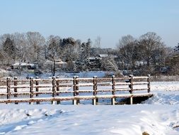 snowy winter in countryside, landscape with wooden bridge