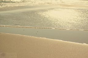 golden sand near the surf of the calm sea