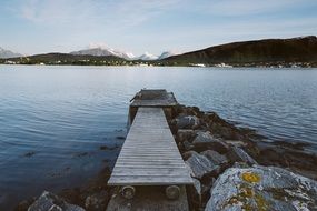 wooden bridge near the water in the mountains