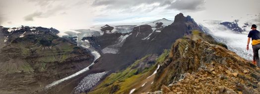 panoramic view of a glacier against a cloudy sky