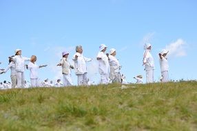 people in white clothes on the mountain