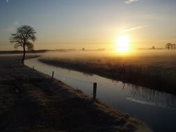 rising sun over the morning mist over the river