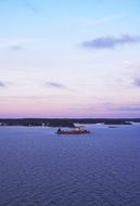 small island with a house in blue water