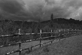 wooden fence in the countryside in france in black white image