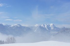 high snow-capped mountains in a sunny haze