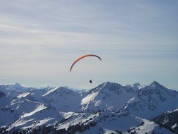 paraglider over the snow-capped peaks of the mountains