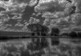 fluffy clouds mirroring on calm lake