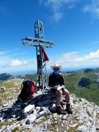 summit cross with man sitting on cima della saline mountain, italy