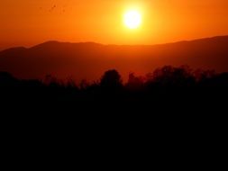 Scenic mountain landscape on the background of orange sunset