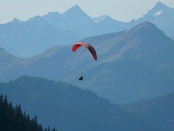 paraglider over the mountains in a blue haze