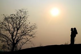 silhouette of a couple in love against the evening gray sky