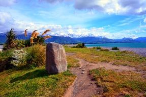 park at distant blue mountains on scenic coastline, new zealand