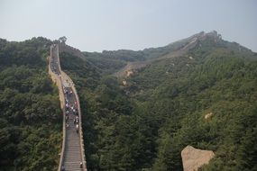 people walking on top of the great wall in mountain landscape, china